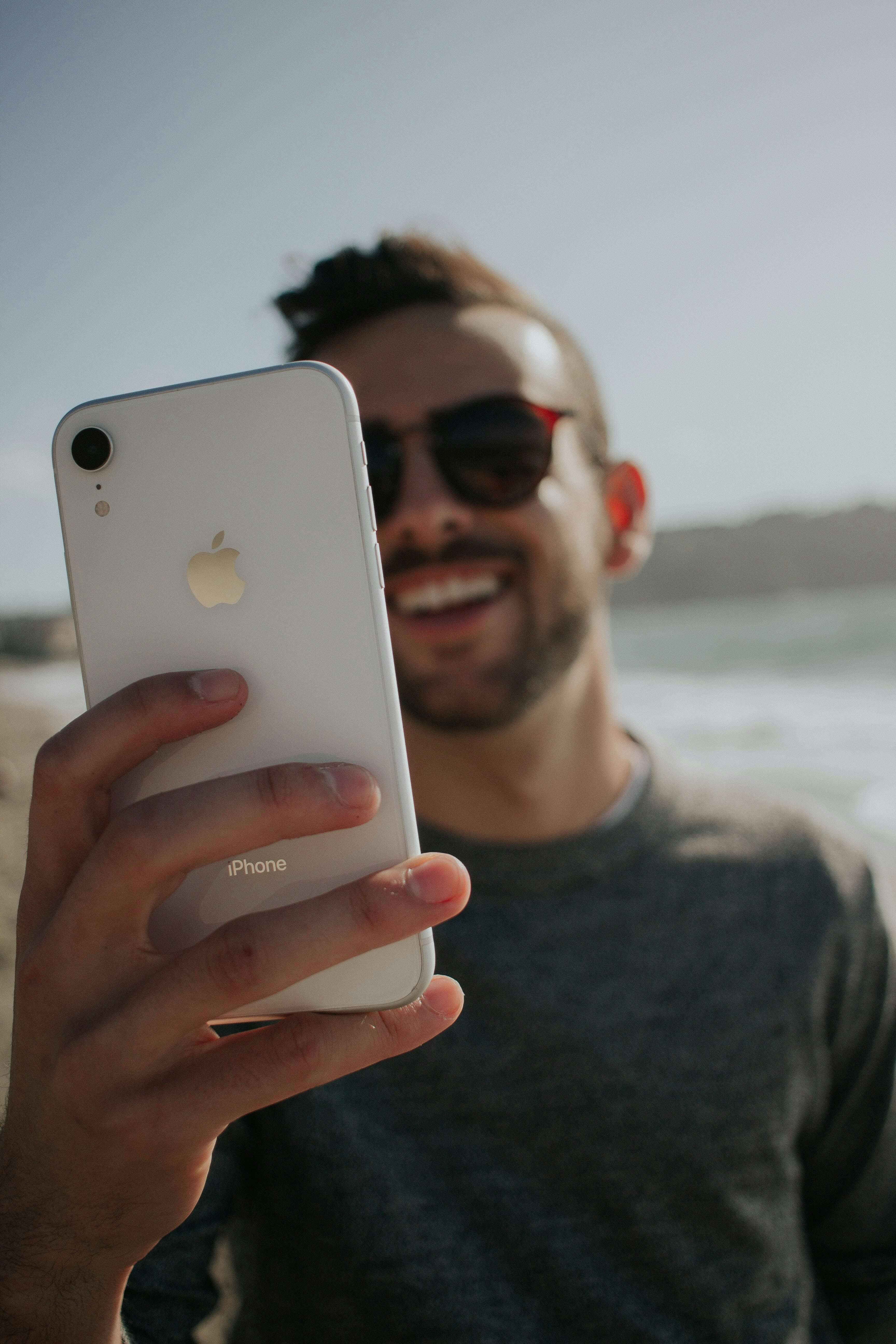 Homme souriant avec un téléphone